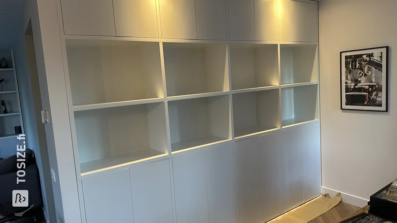 Custom-made cupboard walls for the living room with plenty of storage space, by Bas