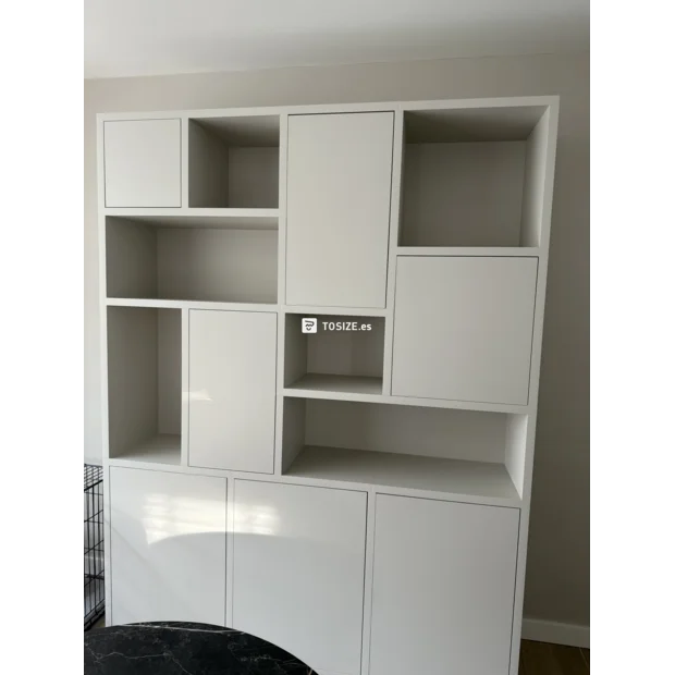 Armario de pared blanco con puertas y compartimentos abiertos