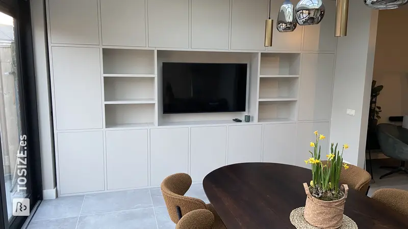 Stylish white built-in TV cabinet with lots of storage space and TV, by Chiel