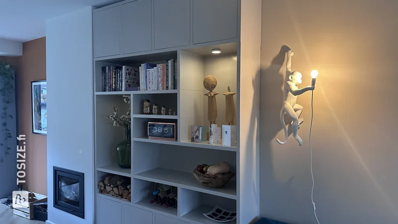 Beige shelving unit with spotlights and doors, by Alex