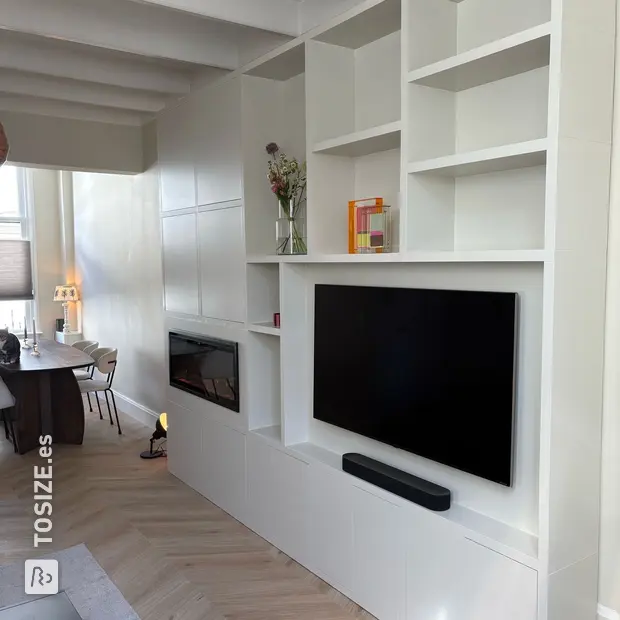 Armario de pared blanco con compartimentos y puertas abiertas.