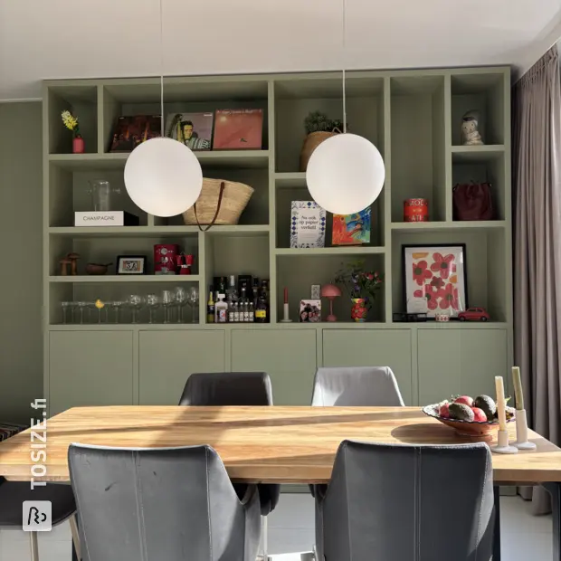 Green cupboard wall with open compartments and doors