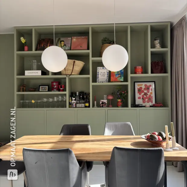 Groene kastenwand met open vakken en deuren