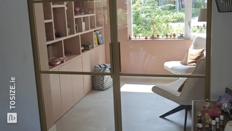 Wall-filling display cabinet in Terra Pink, by Rutger