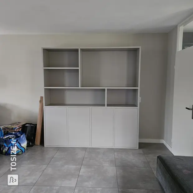 Light gray cupboard wall with doors and open compartments