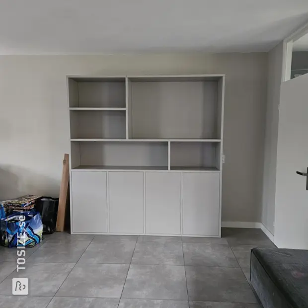 Light gray cupboard wall with doors and open compartments