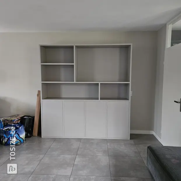 Lichte grijze kastenwand met deuren en open vakken