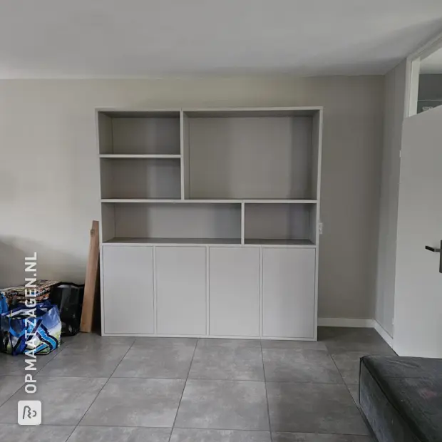 Lichte grijze kastenwand met deuren en open vakken