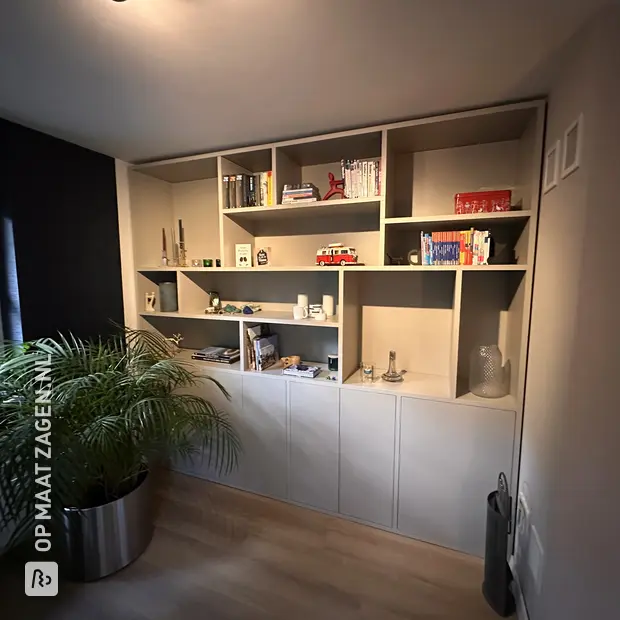Grijze kastenwand met open vakken en deuren