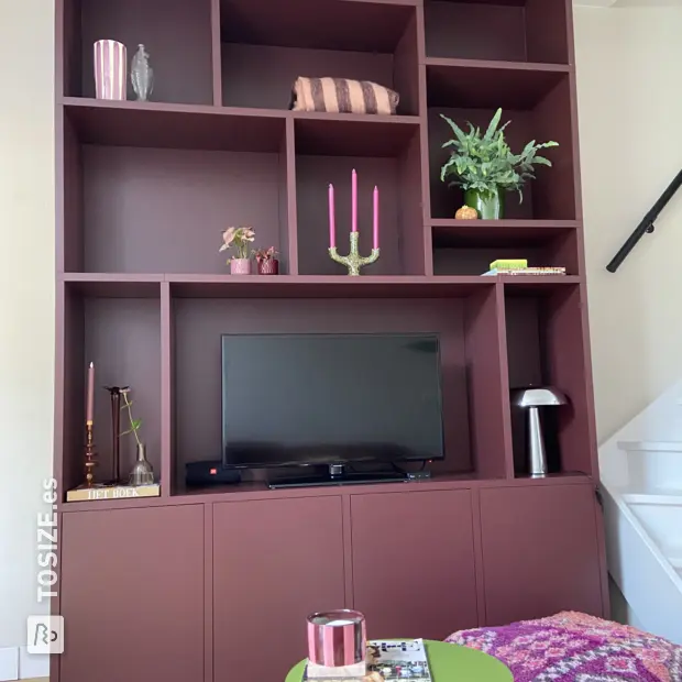 Armario de pared de color rojo intenso con puertas y compartimentos abiertos.