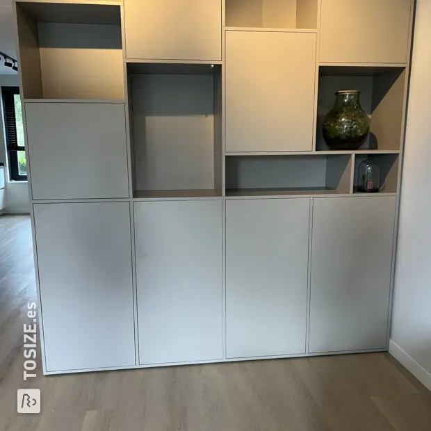 Estantería gris con compartimentos abiertos y puertas.