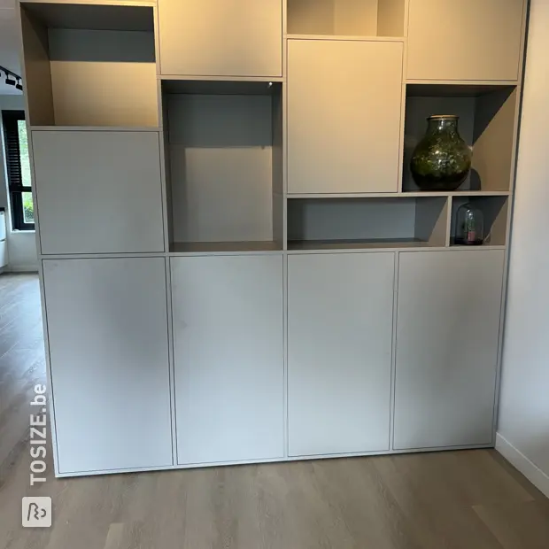 Grijze vakkenkast met open vakken en deuren