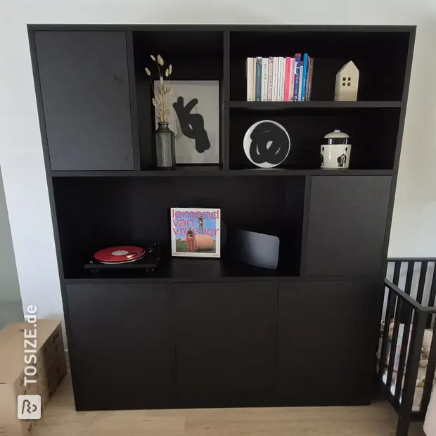 Black cupboard wall with doors and open compartments
