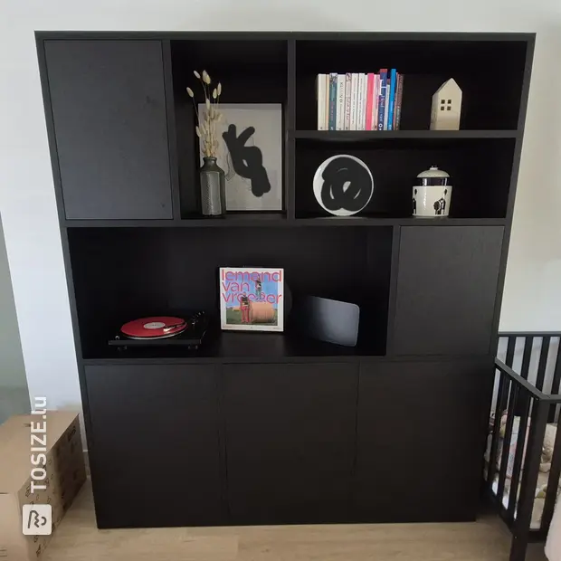 Black cupboard wall with doors and open compartments