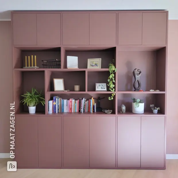 Roze kastenwand met open vakken en deuren