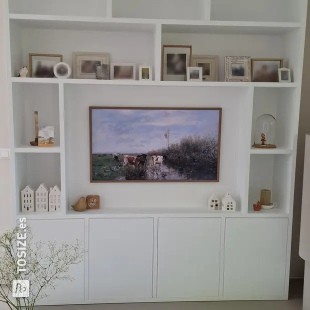 Armario de pared blanco con compartimentos y puertas abiertas.