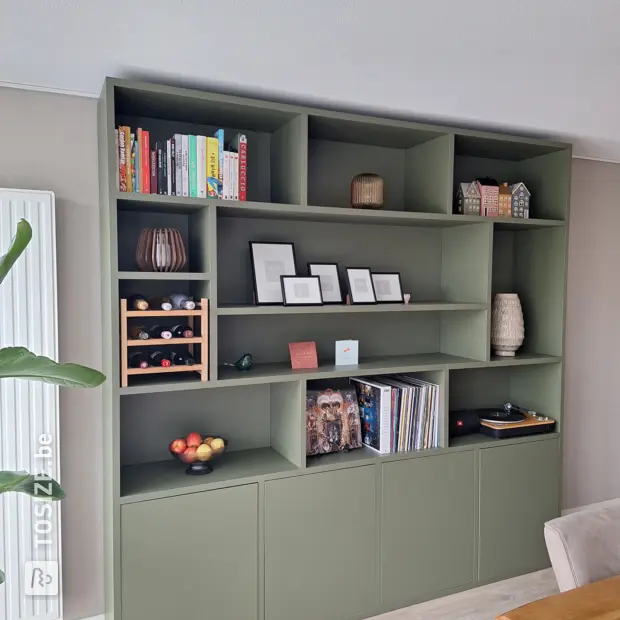 Groene kastenwand met open vakken en deuren