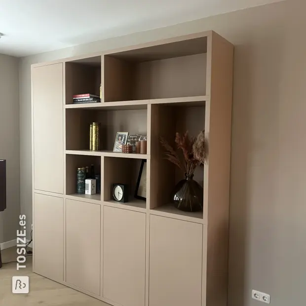 Armario de pared beige con puertas y compartimentos abiertos