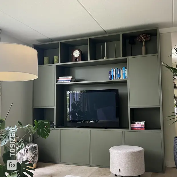 Mur de placard vert avec compartiments ouverts et portes