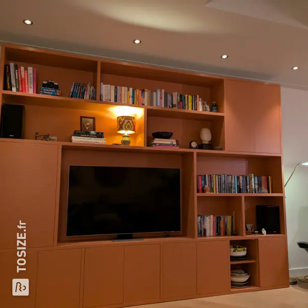 Peach-colored cupboard wall with open compartments and doors