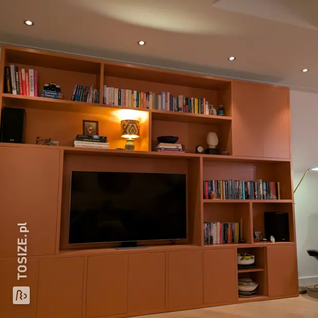 Peach-colored cupboard wall with open compartments and doors