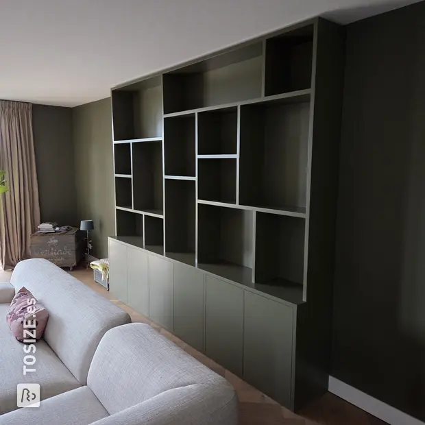 Armario de pared verde con compartimentos y puertas abiertas
