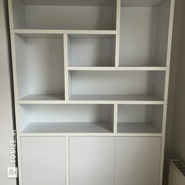 Weiße Schrankwand mit Türen und offenen Fächern