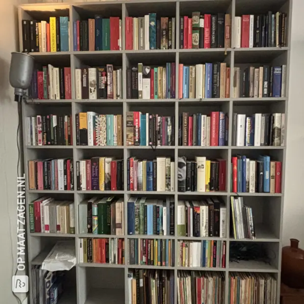 Grijze boekenkast met open vakken en legplanken