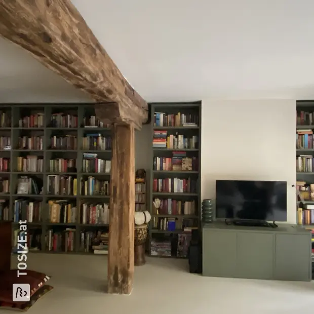 Grünes Bücherregal mit offenen Fächern und Regalböden