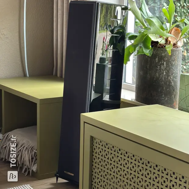 Green shelving unit with open compartments and shelves