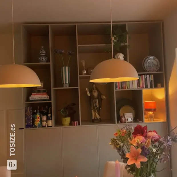 Armario de pared beige con compartimentos y puertas abiertas