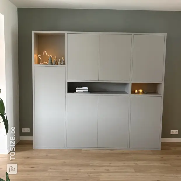 Grijze kastenwand met deuren en open vakken