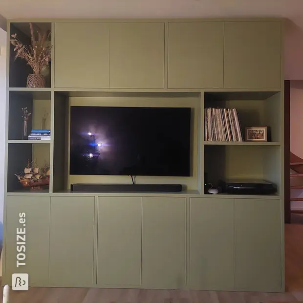 Armario de pared verde con compartimentos y puertas abiertas