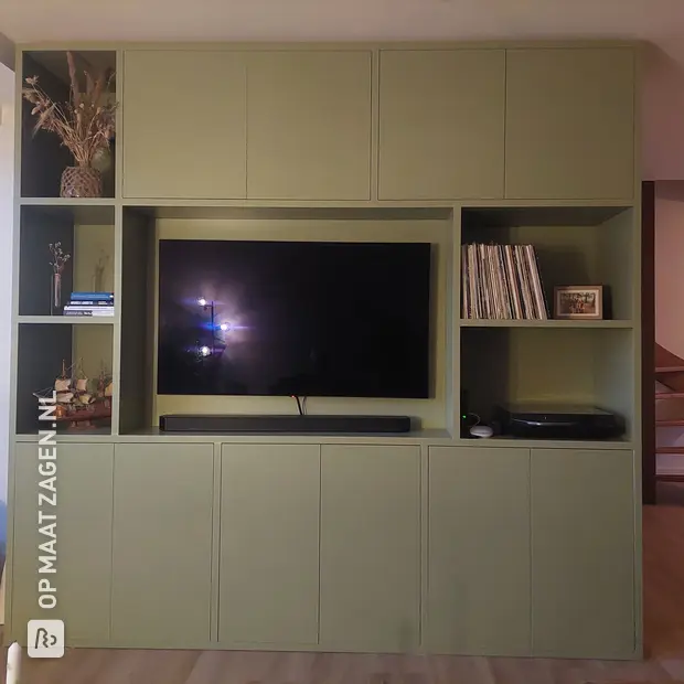 Groene kastenwand met open vakken en deuren