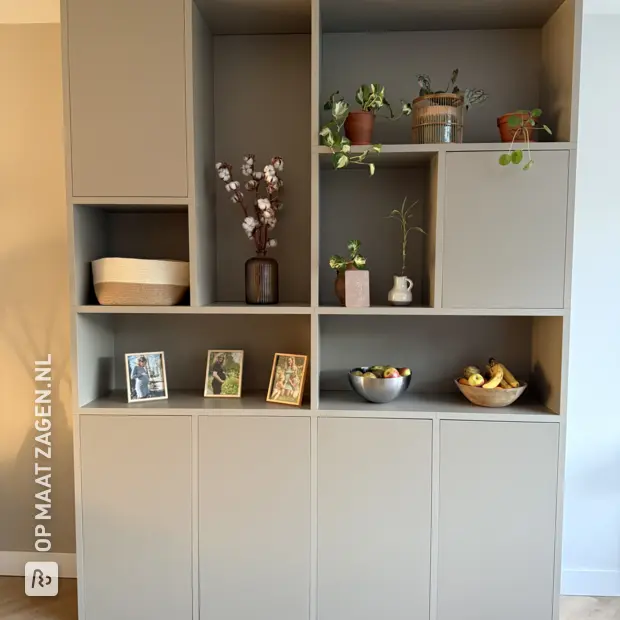 Grijze kastenwand met deuren en open vakken