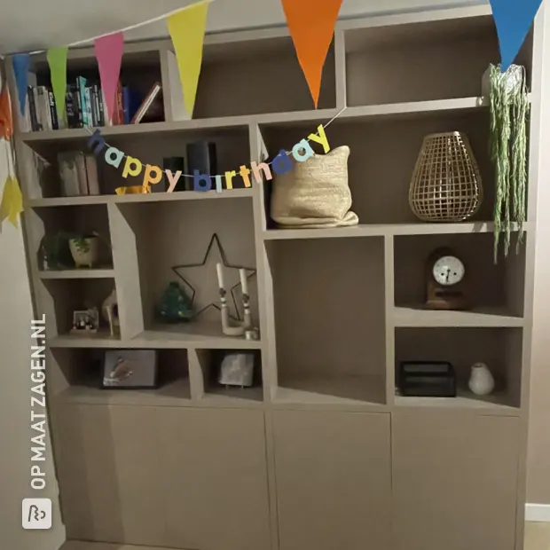 Beige kastenwand met open vakken en deuren