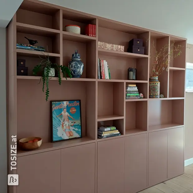 Pink wall unit with open compartments and doors