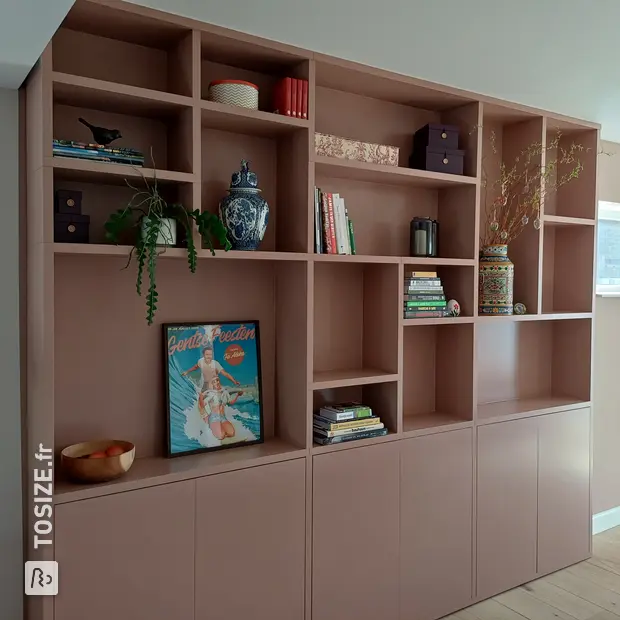 Meuble mural rose avec compartiments et portes ouverts