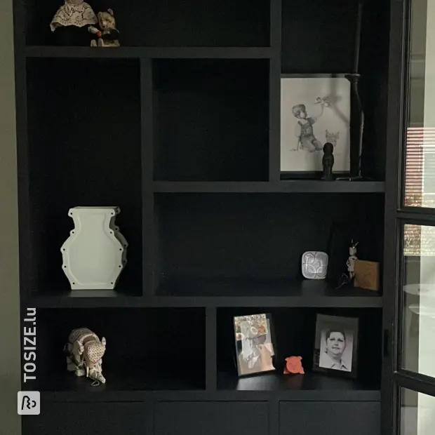 Étagère noire avec portes et compartiments ouverts