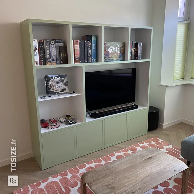 Green cupboard wall with open compartments and doors