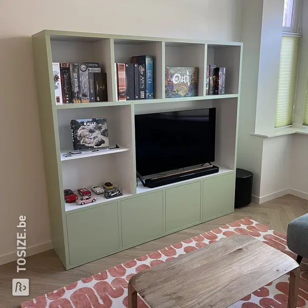 Groene kastenwand met open vakken en deuren