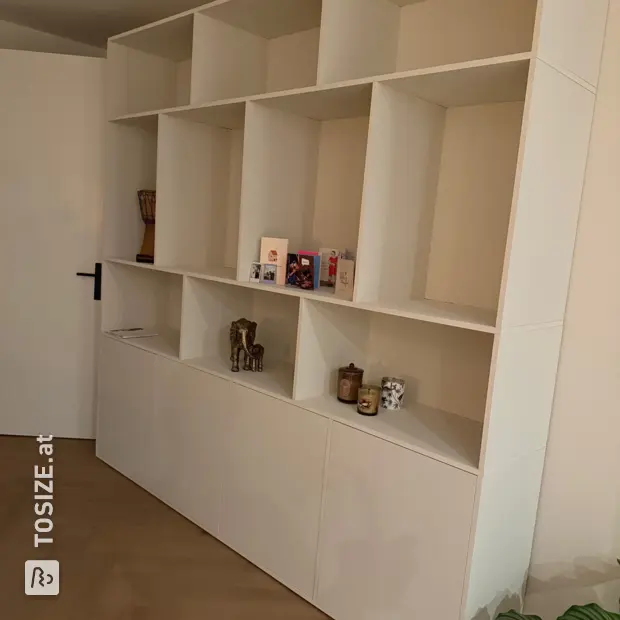 Weißes Wandregal mit offenen Fächern und Türen
