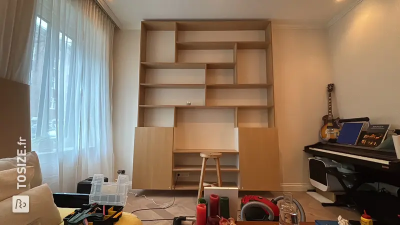 Étagère unique avec placards de cuisine dans le salon, par Jeroen