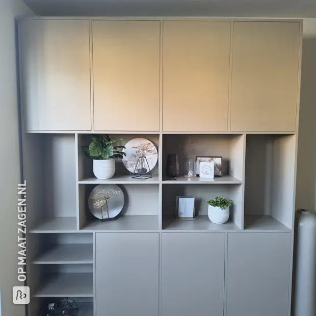 Grijze kastenwand met deuren en open vakken
