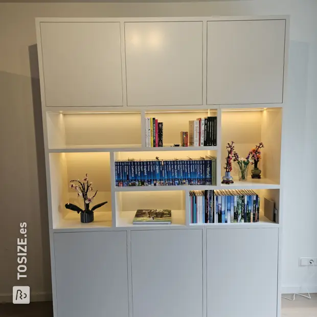 Librería blanca con compartimentos abiertos y puertas.