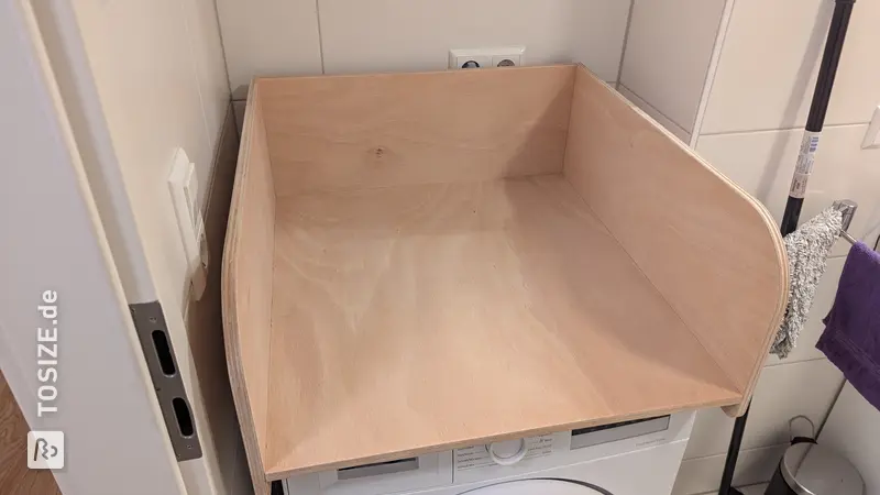 Practical changing table attachment for the washing machine, by Robert