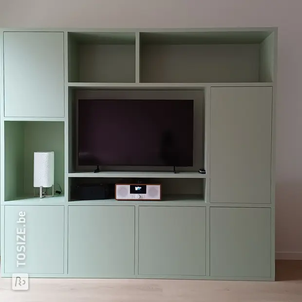 Groene kastenwand met open vakken en deuren