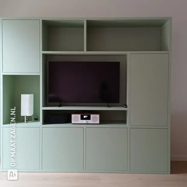 Groene kastenwand met open vakken en deuren