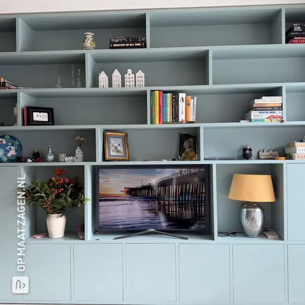 Blauwe kastenwand met open vakken en deuren