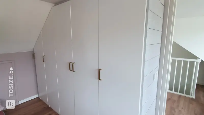 Op maat gemaakte kledingkast onder een schuin dak, door Marleen